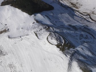 Oblique aerial view of fort and cultivation remains and enclosure under snow, looking to N.