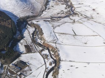 General oblique aerial view of rig and furrow, and church and graveyard under snow, looking to N.