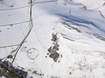 General oblique aerial view of scooped settlement and settlement  under snow, looking to NNE.