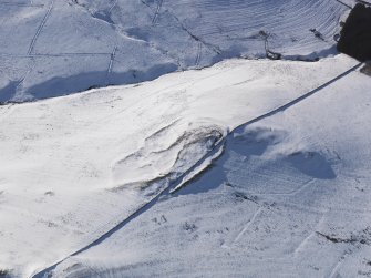 Oblique aerial view of settlement and rig under snow, looking to W.