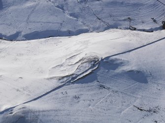 Oblique aerial view of settlement and rig under snow, looking to W.