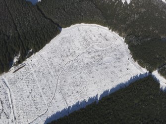 Oblique aerial view of scooped settlement under snow, looking to NE.