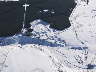 Oblique aerial view of the lime kilns and quarry under snow, looking SE.