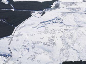 Oblique aerial view of lime kilns and quarries under snow, looking SE.