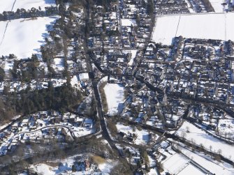 Oblique aerial view of West Linton under snow, looking NE.