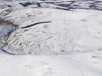 General oblique aerial view of settlement, rig and field banks under snow, looking W.