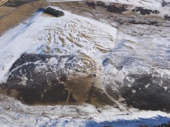 Oblique aerial view of Chester Rig fort and settlement under snow, looking NE.