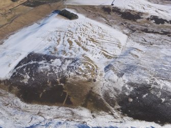 Oblique aerial view of Chester Rig fort and settlement under snow, looking NNE.