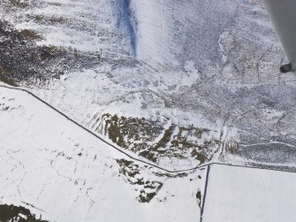 Oblique aerial view of fort and settlement under snow, looking W.