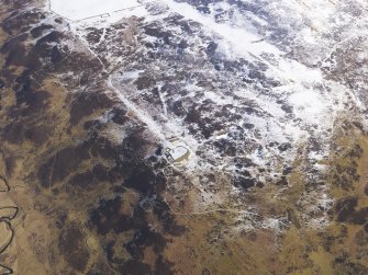 Oblique aerial view of settlement under snow, looking NE.