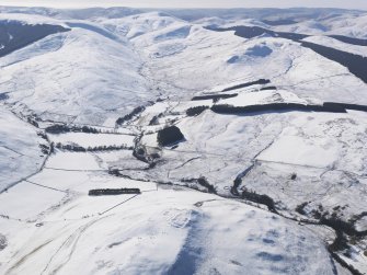 General oblique aerial view with the Burgh Hill fort in the foreground and Holywell Rig and Skelfhill beyond, looking SW.