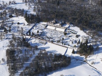 Oblique aerial view of Drummond Castle and gardens under snow, looking NNW.