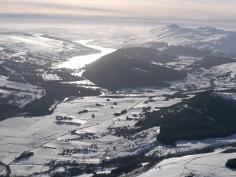 General oblique aerial view under snow of Dull with Kenmore and Loch Tay beyond, looking SW.