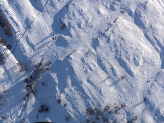 Oblique aerial view of the cairnfield, field boundaries, shieling huts and rig, looking SSW.