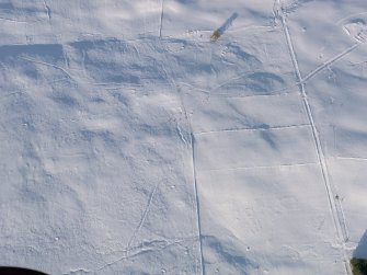 Oblique aerial view of the township, field boundaries and small cairns, looking NE.