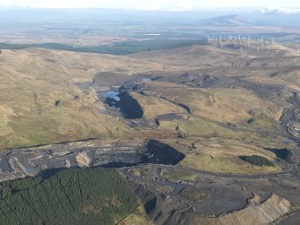 General oblique aerial view of the Viaduct Mine opencast workings and the site of Glenbuck Village with the Common Hill wind farm beyond, taken from thee WSW.