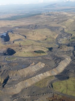 General oblique aerial view of the Viaduct Mine opencast workings and the site of Glenbuck Village with the Common Hill wind farm beyond, taken from thee SW.