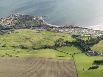 General oblique aerial view looking across the golf course towards Kinghorn, with the caravan park and the remains of the anti-aircraft battery adjacent, taken from the N.