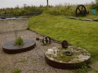 View of mill stones (runner to left, bed to right) used as garden ornaments.