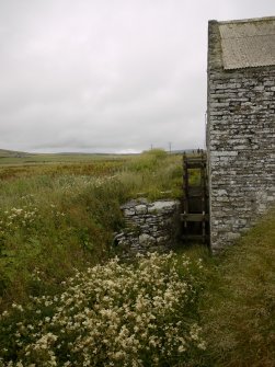 View from W of skeleton of overshot iron and wood waterwheel: note remains of lade watercontrol lever that could be operated from the milling floor.