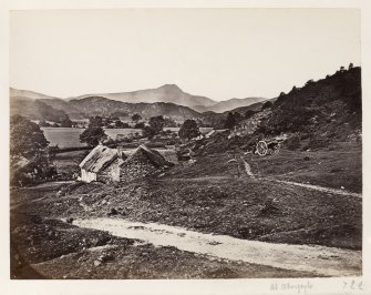 Page 5/3 View of farmstead with handcart and man.
Titled 'At Aberfoyle.'
PHOTOGRAPHER ALBUM 146: THE ANNAN ALBUM Undated photograph , approximately c.1880.