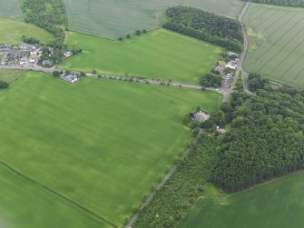 Oblique aerial view of the cropmarks of the possible barrow with Woodend beyond, looking SSE.