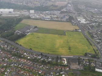 Oblique aerial view of the cropmarks of the ring ditches, looking SE.