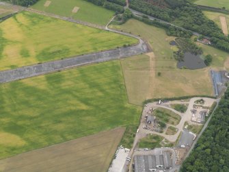 Oblique aerial view of the cropmarks of the ring ditch and the field boundaries at Castle Kennedy airfield, taken from the NNE.