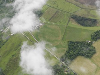 Oblique aerial view of the grassmarks of the enclosure and possible barrows, taken from the NNE.