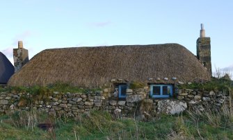 View of the West elevation of the thatched cottage at 13 Kilmoluaig, Tiree, taken from the West.