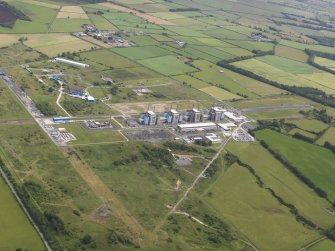 General oblique aerial view of Chapel Cross nuclear power station and the remains of Annan airfield, taken from the WSW.
