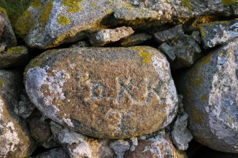 Detailed view of inscribed stone within the thatched cottage at Kilkenneth, Tiree.