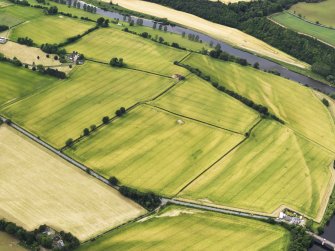 Oblique aerial view of the cropmarks of the Roman Temporary Camps at Mertoun Bridge, taken from the ESE.