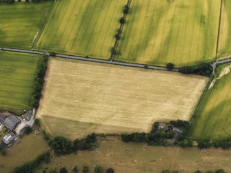 Oblique aerial view of the cropmarks of the field boundary on the S side of the Roman Temporary Camps at Mertoun Bridge, taken from the SSE.