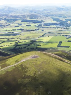 Oblique aerial view of the remains of the cairn on Tinto Hill, with the Upper Clyde valley beyond, taken from the WNW.