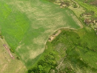 Oblique aerial view centred on the parchmarks of the barrow, taken from the NNE.