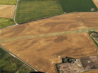 Oblique aerial view of the cropmarks of the buildings at the former airfield, looking to the SSE.