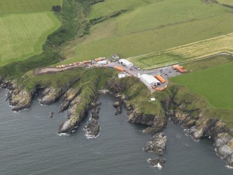 Oblique aerial view of the survival craft inspectorate yard and the site of St Ternan's Chapel and Well, looking to the WNW.