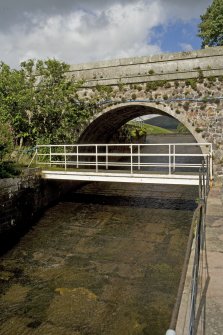 General view of bridge over the spillway leading from the leading the dam, from E.