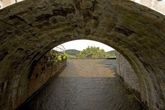 General view of the sluice leading from the leading the dam, from SE.