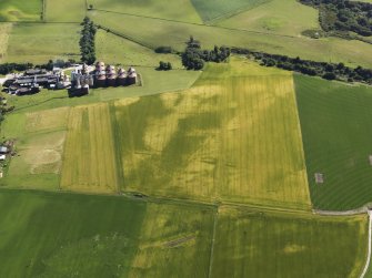 Oblique aerial view of the cropmarks of the pits and field boundaries with Portgordon Maltings adjacent, looking to the SW.