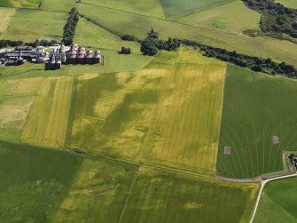 Oblique aerial view of the cropmarks of the pits and field boundaries with Portgordon Maltings adjacent, looking to the SSW.