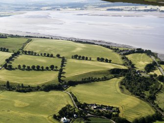 General oblique aerial view of the cropmarks of the rig with the fishtap on the S shore of the Beauly Firth beyond, looking to the NW.