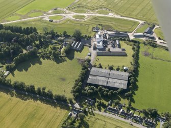 Oblique aerial view of Royal Brackla Distillery and Brackla House, looking to the NNW.