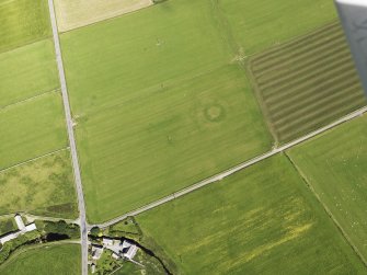 Oblique aerial view of the Hall of Ireland with a vegetation mark showing the ditch and the Mill of Ireland adjacent, taken from the SE.