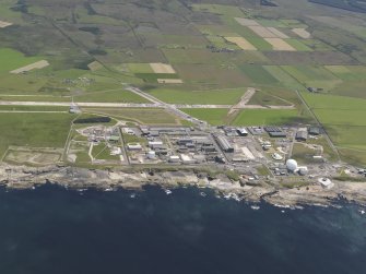 General oblique aerial view of the Dounreay Nuclear Research Facility with the airfield beyond, taken from the NW.