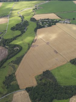 General oblique aerial view of the Glasgow University excavations of the Forteviot complex of sites with the village beyond, looking to the N.