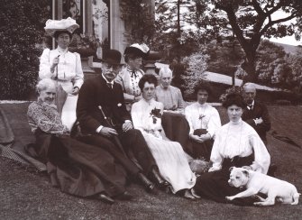 View of group of people sitting in garden.
Titled: 'Aikenshaw July 1905. Miss Louise Stuart, Miss Grant, Mr Parker, Miss Parker, Francess, Mrs Jameson, Miss Davidson, Jessie, Mr W S Turnbull, Stroncher'. 
PHOTOGRAPH ALBUM No.21: CYCLE TOUR ALBUM.
