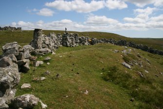 View from W of the probable hut-circle (HU24NE 179) underlying the later enclosure wall.