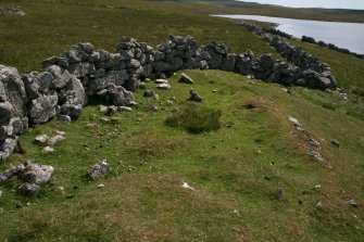 View from W of the probable hut-circle (HU24NE 179) underlying the later enclosure wall.